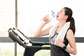 Beautiful asian woman rest drinking water bottle after treadmill Royalty Free Stock Photo