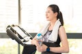 Beautiful asian woman rest holding water bottle after treadmill Royalty Free Stock Photo