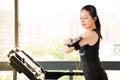Beautiful asian woman running treadmill use smartphone listening Royalty Free Stock Photo