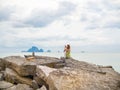 Beautiful asian woman with short hair using smart phone take a photo seascape view