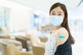 Beautiful Asian woman showing a vaccination injection point at her arm. Royalty Free Stock Photo