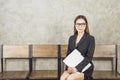 A beautiful Asian woman sits on a wooden chair while waiting for an interview with the company`s human resources committee, Royalty Free Stock Photo