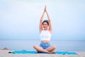 Beautiful Asian woman sitting on the beach exercising and practicing yoga. Royalty Free Stock Photo