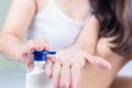 A beautiful Asian woman sitting on a bed pressing the cream Use body creams and lotions.