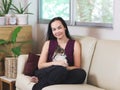 Asian woman sitting on couch in living room with her Chihuahua dog on lap smiling and looking at camera , stay home , social Royalty Free Stock Photo