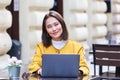 Beautiful Asian woman sitting with portable net-book laptop in modern cafe bar, young charming asian female freelancer thinking Royalty Free Stock Photo