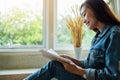 A beautiful asian woman sitting and reading book at home Royalty Free Stock Photo