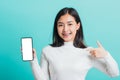 Woman smile holding a smartphone on hand and pointing finger to the blank screen Royalty Free Stock Photo