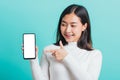 Woman smile holding a smartphone on hand and pointing finger to the blank screen Royalty Free Stock Photo