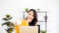 Beautiful asian woman smile and wearing yellow shirt and sitting in workplace room at home