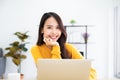 Beautiful asian woman smile and wearing yellow shirt and sitting in workplace room at home