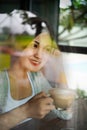 A beautiful Asian woman smiles happily with coffee in the restaurant. Lifestyle of young women during the relaxing time in the