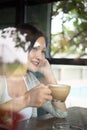 A beautiful Asian woman smiles happily with coffee in the restaurant. Lifestyle of young women during the relaxing time in the Royalty Free Stock Photo