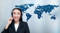 Beautiful asian woman smiling customer service talking on headset with world map communication. Royalty Free Stock Photo