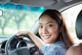 Beautiful Asian woman smiling and enjoying.driving a car on road