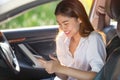Beautiful asian woman smiling while sitting in the car. Girl is using a smartphone Royalty Free Stock Photo