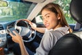 Beautiful asian woman smiling and using navigation app on smartphone while driving a car Royalty Free Stock Photo