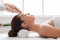 Beautiful Asian woman in spa salon enjoying acupressure head massage, side view Royalty Free Stock Photo