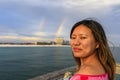 Beautiful Asian woman standing on Pensacola fishing pier with a double rainbow Royalty Free Stock Photo