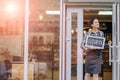 Beautiful asian woman store owner with standing in the doorway of her coffee shop looking at camera and smiling.Portrait