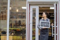 Beautiful asian woman store owner with standing in the doorway of her coffee shop looking at camera and smiling.Portrait