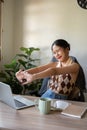 A beautiful Asian woman is stretching her arms to relax after finishing her work at her desk Royalty Free Stock Photo