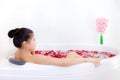 Beautiful asian woman takes a bath in jacuzzi with rose petals Royalty Free Stock Photo