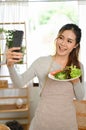 Beautiful Asian woman taking selfie of herself and her homemade salad. Healthy lifestyle Royalty Free Stock Photo