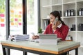 Beautiful asian woman talking on phone at creative office. Happy smiling businesswoman answering telephone at office Royalty Free Stock Photo