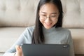 Beautiful of asian woman touching keyboard on modern digital tablet, Asia girl smiling while working  in her home Royalty Free Stock Photo