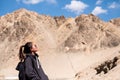 A beautiful Asian woman tourist standing in front of mountain and blue sky background