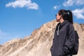 A beautiful Asian woman tourist standing in front of mountain and blue sky background Royalty Free Stock Photo