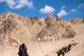 A beautiful Asian woman tourist standing in front of mountain and blue sky background Royalty Free Stock Photo