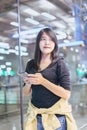 Beautiful Asian woman traveler using mobile phone in airport, Lifestyle using cell phone Royalty Free Stock Photo