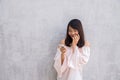 Beautiful asian woman using cellphone, over concrete wall Royalty Free Stock Photo