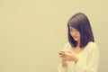 Beautiful asian woman using cellphone, over concrete wall. Royalty Free Stock Photo