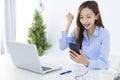 Beautiful asian woman using smartphone, exciting and celebrating with good news of business successful