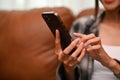 Beautiful Asian woman using smartphone while relaxing in her living room. cropped image Royalty Free Stock Photo