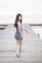 Beautiful asian woman walking on wood pier with relaxing emotion and smiling to camera use for attractive teen age , woman and