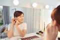 Beautiful Asian woman wearing earring in front of the mirror Royalty Free Stock Photo