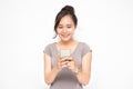 Beautiful Asian woman wearing grey casual shirt holding smartphone on white background and copy space.  Cute Asian woman is Royalty Free Stock Photo