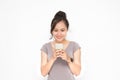 Beautiful Asian woman wearing grey casual shirt holding smartphone on white background and copy space.  Cute Asian woman is Royalty Free Stock Photo