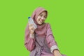 Smiling muslim woman holding water bottle with green background