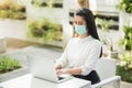 Beautiful asian woman wearing protection mask work from home in the morning. Young asian female with laptop stay at home Royalty Free Stock Photo