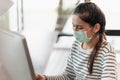 Beautiful asian woman wearing protection mask work from home in the morning. Young asian female working with computer stay at home Royalty Free Stock Photo