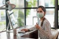 Beautiful asian woman wearing protection mask work from home in the morning. Young asian female working with computer stay at home Royalty Free Stock Photo