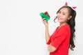 Beautiful Asian woman wearing small Santa hat and wearing red dress holding red gift box on white background Royalty Free Stock Photo