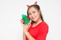 Beautiful Asian woman wearing small Santa hat and wearing red dress holding red gift box on white background Royalty Free Stock Photo