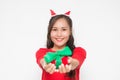 Beautiful Asian woman wearing small Santa hat and wearing red dress holding red gift box on white background Royalty Free Stock Photo