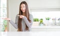 Beautiful Asian woman wearing stripes sweater amazed and smiling to the camera while presenting with hand and pointing with finger Royalty Free Stock Photo